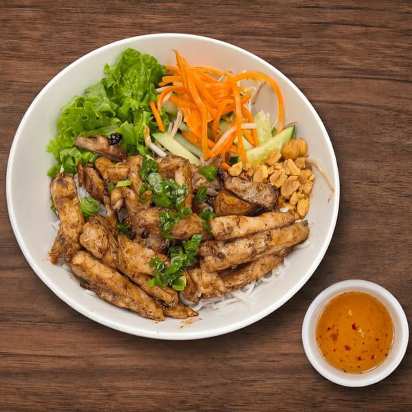 Grilled chicken, rice noodles, lettuce, carrots, cucumbers, peanuts, and scallions with a side of sauce.